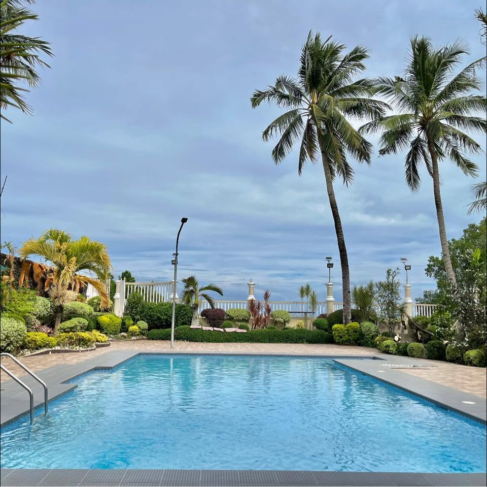Quality Beach Resort swimming pool with tropical palm trees